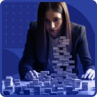 A woman in a suit intensely focuses on a partially built tower made of rectangular blocks on a table. The background is blue with abstract dotted and curved patterns, reflecting the dynamic journey of women in business.