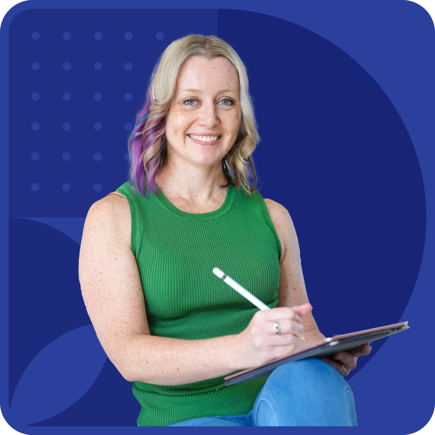 Smiling person with shoulder-length blonde hair and purple highlights, wearing a green sleeveless top, holding a stylus and tablet. The background features a blue geometric design with dots and shapes.