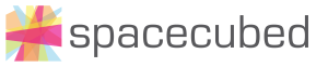 The image displays the Spacecubed logo, featuring a colorful, abstract geometric design on the left and the word "spacecubed" in lowercase gray text on the right. This vibrant design reflects their commitment to supporting entrepreneurs and women in business.