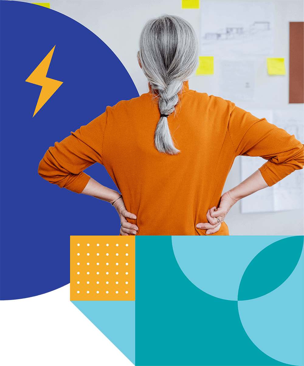 A person with long gray hair tied in a low braid stands with hands on hips, facing a wall filled with business ideas for women written on various papers and sticky notes. They are wearing an orange shirt. The image is overlaid with abstract geometric shapes in blue, yellow, and turquoise.